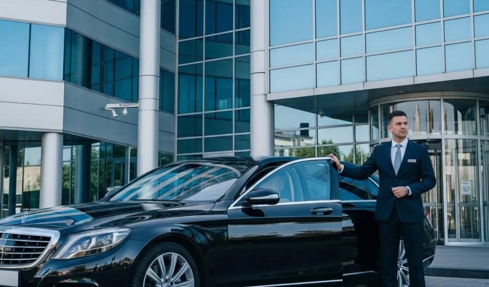 Luxury chauffeur vehicle in front of a corporate building representing executive travel security